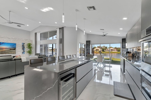 kitchen with ceiling fan, gray cabinetry, hanging light fixtures, wine cooler, and vaulted ceiling