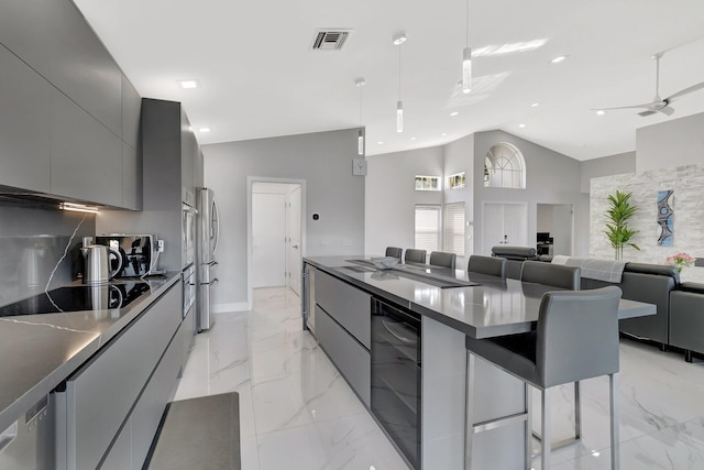 kitchen featuring decorative light fixtures, gray cabinetry, wine cooler, a kitchen bar, and black electric stovetop