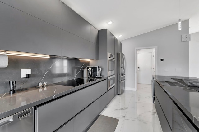 kitchen with decorative light fixtures, tasteful backsplash, lofted ceiling, dark stone counters, and stainless steel appliances