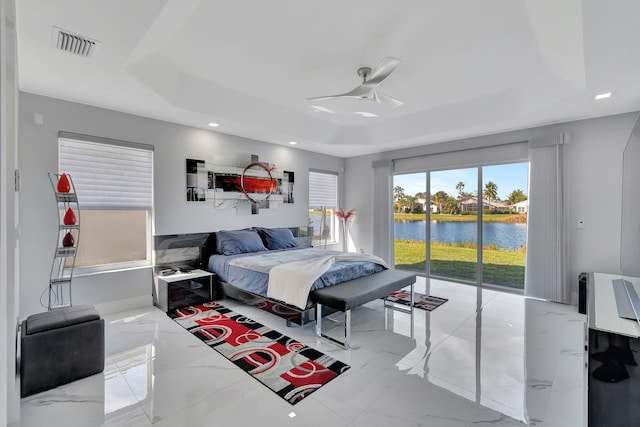 bedroom with a water view, ceiling fan, access to exterior, and a raised ceiling