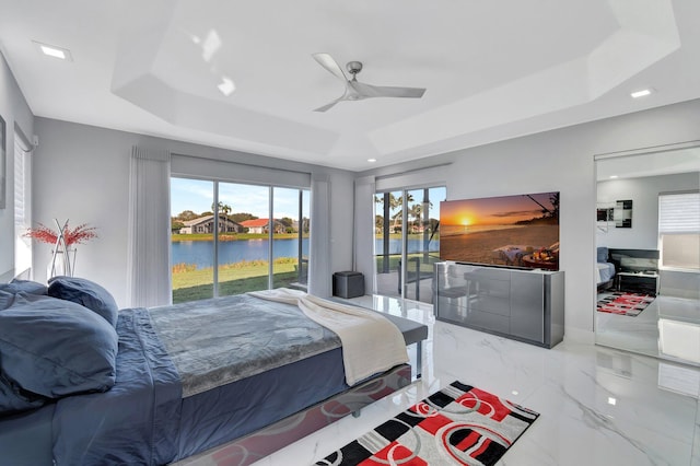 bedroom featuring ceiling fan, a tray ceiling, and access to outside