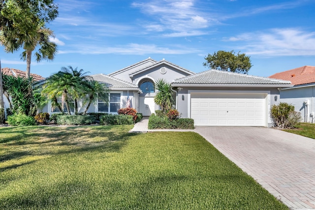 single story home with a garage and a front lawn