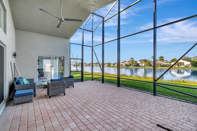 unfurnished sunroom with a water view and ceiling fan