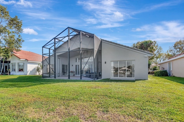 back of property featuring glass enclosure, a patio area, and a lawn