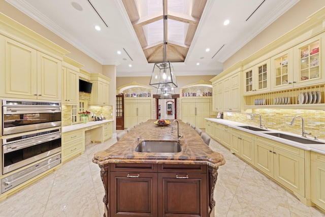 kitchen with decorative light fixtures, cream cabinetry, and decorative backsplash