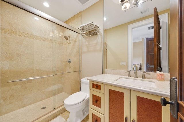 bathroom featuring vanity, a shower with shower door, and toilet