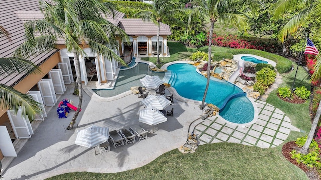 view of pool featuring a patio area, an outdoor structure, and a lawn