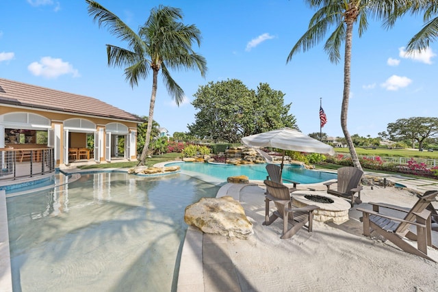 view of swimming pool featuring an outdoor structure, a patio area, and a fire pit