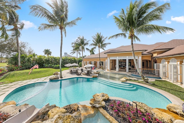 view of swimming pool featuring a lawn and a patio area