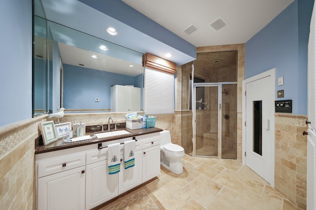 bathroom with walk in shower, vanity, toilet, and tile walls