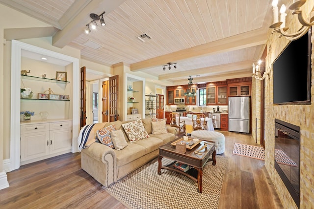 living room featuring beamed ceiling, a large fireplace, dark hardwood / wood-style flooring, and wooden ceiling