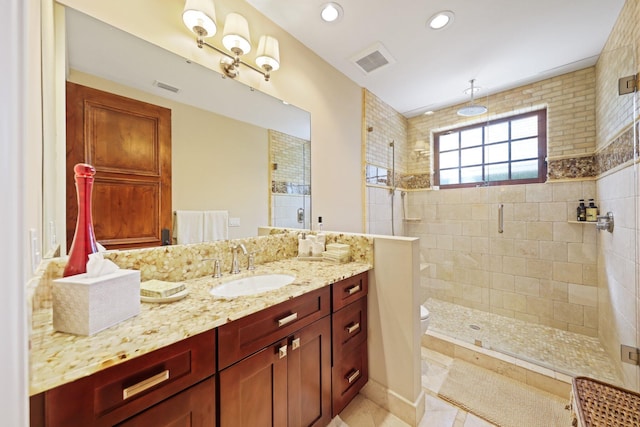 bathroom featuring vanity, toilet, and a shower with shower door