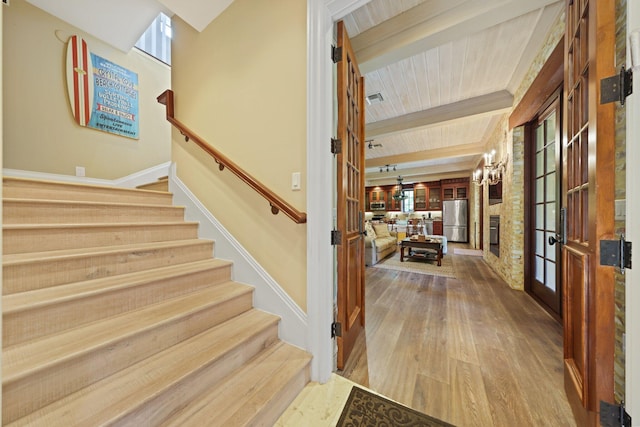 staircase featuring beam ceiling, plenty of natural light, french doors, and hardwood / wood-style flooring