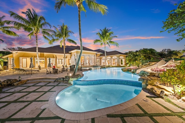 pool at dusk with a patio