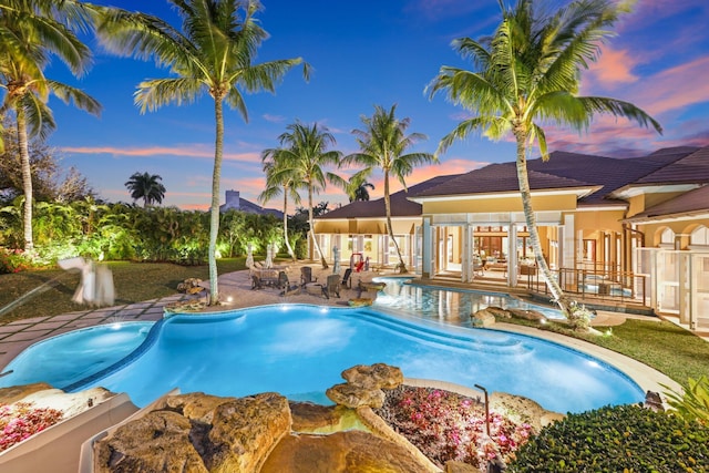 pool at dusk with a patio