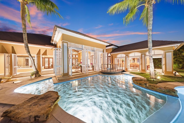 pool at dusk with a patio