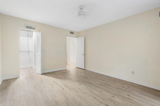 unfurnished bedroom with a closet and light wood-type flooring