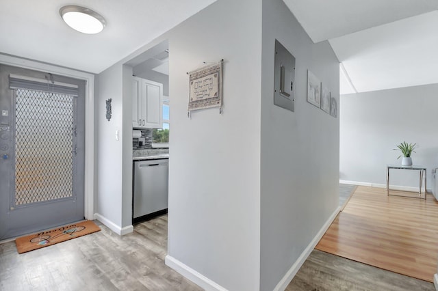 corridor with electric panel and light hardwood / wood-style floors