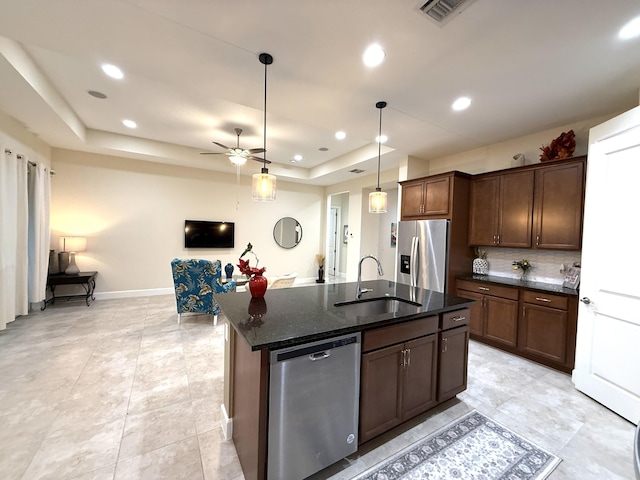 kitchen featuring a center island with sink, ceiling fan, appliances with stainless steel finishes, pendant lighting, and sink