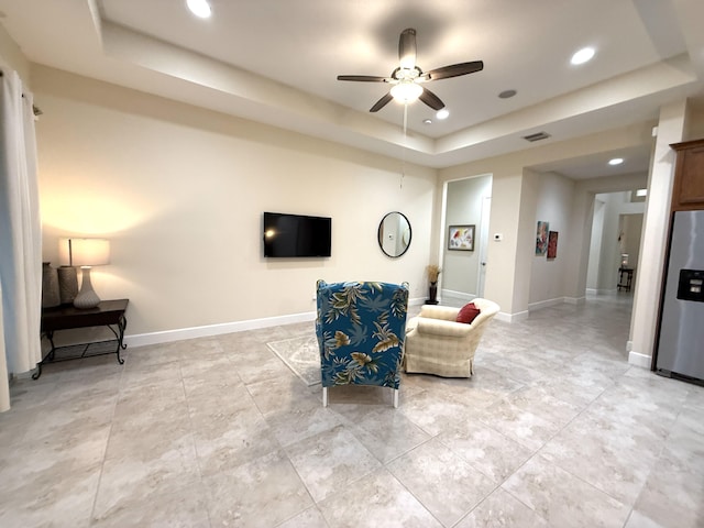 interior space featuring ceiling fan and a raised ceiling