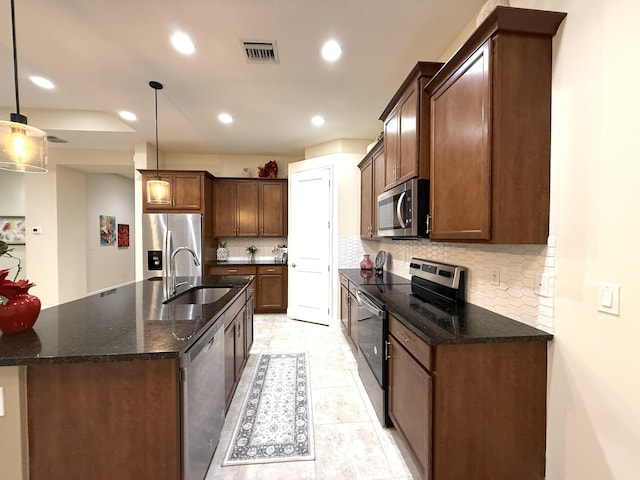 kitchen with appliances with stainless steel finishes, pendant lighting, and backsplash