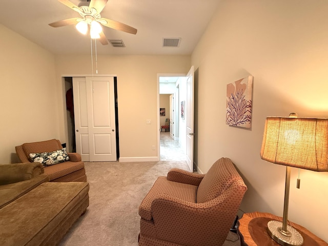 living area with ceiling fan and light colored carpet