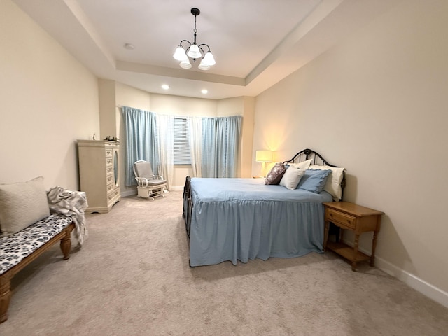 bedroom featuring carpet, a raised ceiling, and a notable chandelier