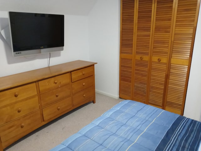 bedroom featuring light colored carpet and a closet