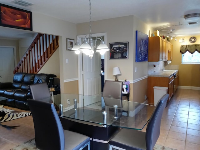 dining space with sink, light tile patterned floors, and a chandelier