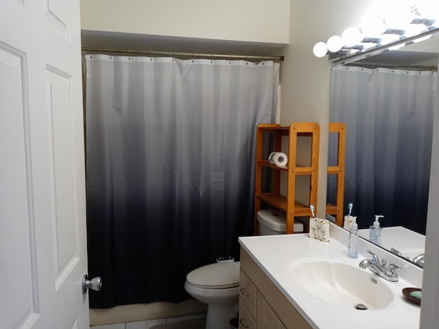 bathroom featuring toilet, vanity, and walk in shower