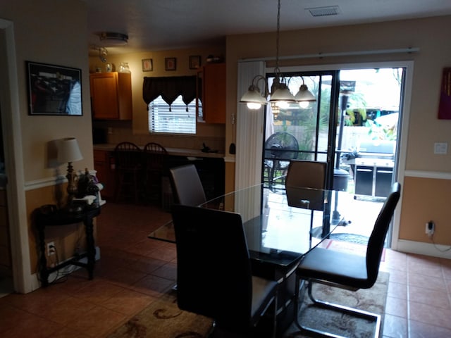 tiled dining space featuring a chandelier