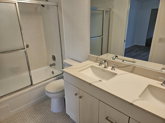 full bathroom with tile patterned floors, enclosed tub / shower combo, vanity, and toilet