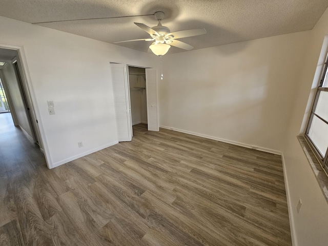 unfurnished bedroom with ceiling fan, dark wood-type flooring, and a textured ceiling