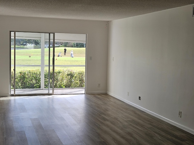 empty room with a textured ceiling, dark hardwood / wood-style flooring, and a healthy amount of sunlight