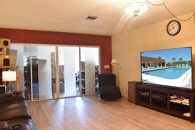 living room with a textured ceiling and light wood-type flooring