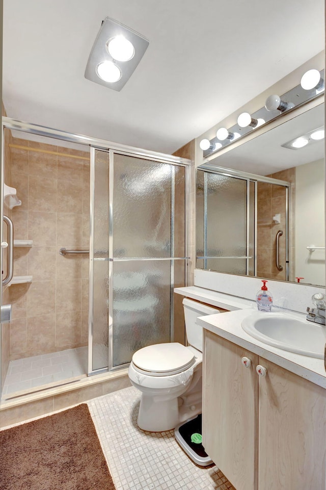 bathroom featuring a shower with shower door, tile patterned floors, vanity, and toilet