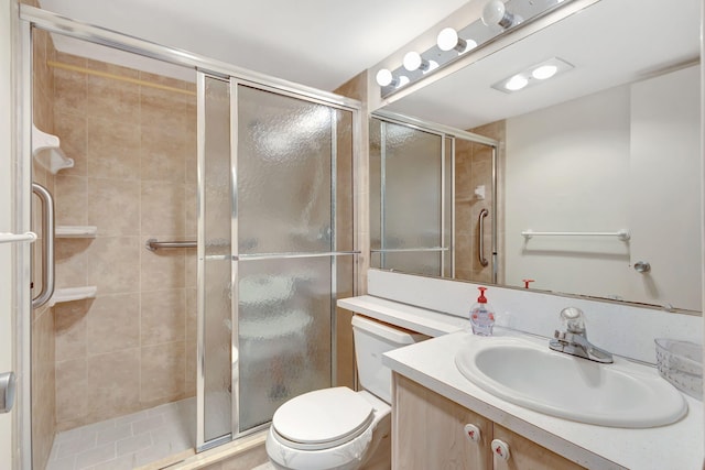 bathroom featuring toilet, an enclosed shower, and vanity