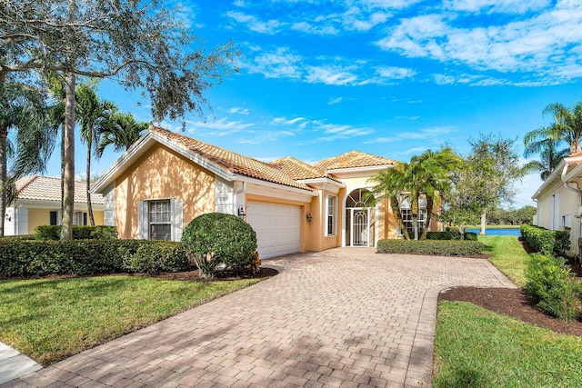 mediterranean / spanish-style home featuring a front yard and a garage