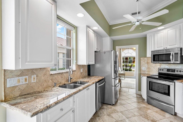 kitchen featuring appliances with stainless steel finishes, ornamental molding, white cabinetry, and sink