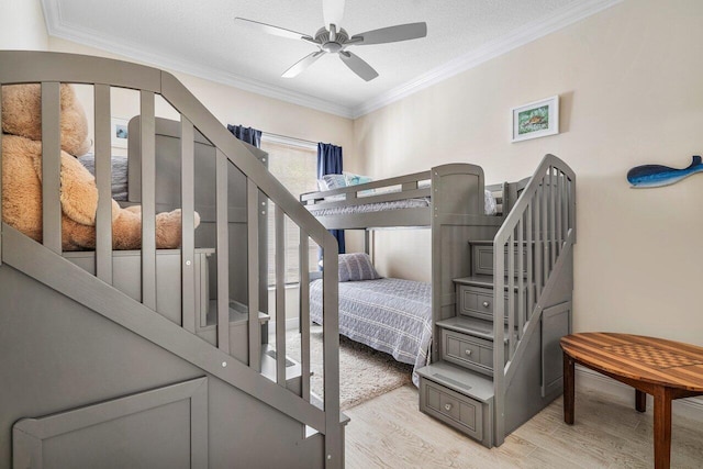 bedroom featuring ceiling fan, ornamental molding, a textured ceiling, and light hardwood / wood-style floors