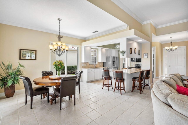 dining area featuring light tile patterned floors, a notable chandelier, sink, and crown molding