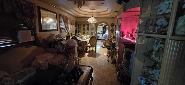 miscellaneous room featuring ornamental molding, cooling unit, and a tray ceiling