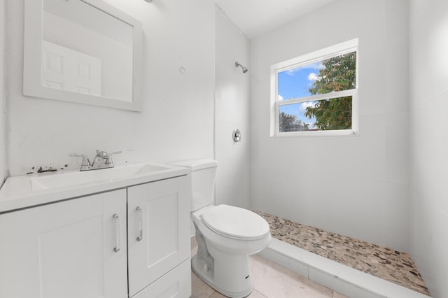 bathroom featuring toilet, vanity, tile patterned floors, and walk in shower