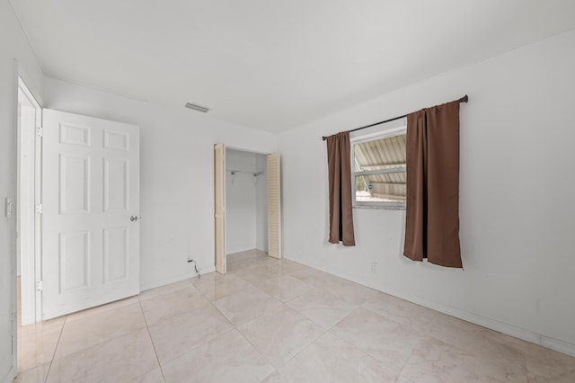 unfurnished bedroom featuring a closet and light tile patterned flooring