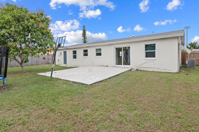 rear view of property with a patio area, cooling unit, and a lawn