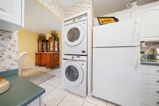 laundry room featuring light tile patterned floors and stacked washer and clothes dryer