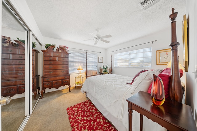 carpeted bedroom with ceiling fan and a textured ceiling