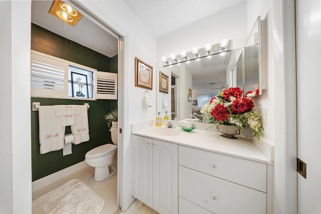 bathroom featuring toilet, vanity, tile patterned floors, and a textured ceiling