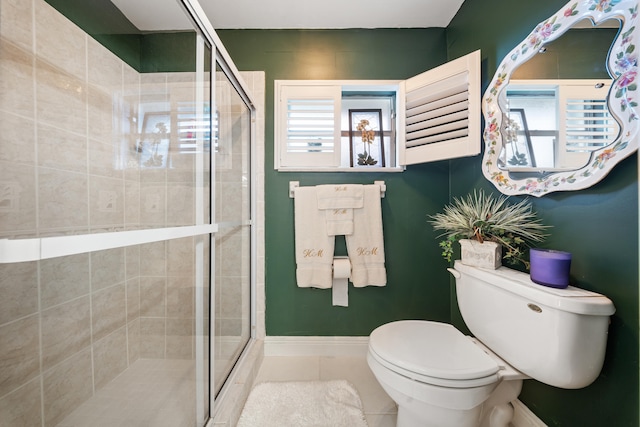 bathroom with an enclosed shower, tile patterned flooring, and toilet