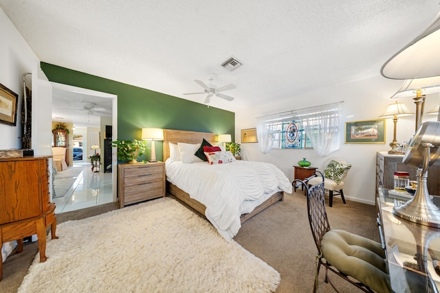 bedroom with ceiling fan, a textured ceiling, and carpet flooring